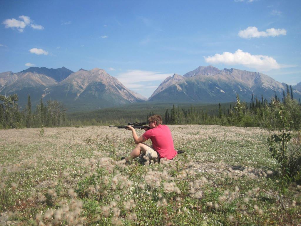 instructor travis with firearm in an alpine meadow